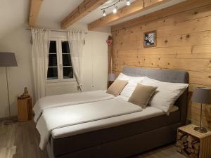 a bedroom with a large bed with a wooden wall at Ybrig Lodge in Unteriberg