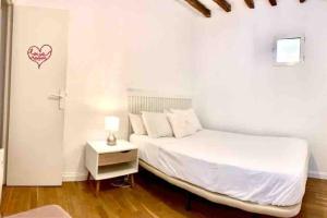 - une chambre blanche avec un lit et une table de nuit dans l'établissement Céntrico y cómodo apto en Opera Palacio Real Aire Acondicionado WiFi, à Madrid