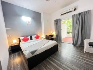 a bedroom with a bed with red pillows on it at BedChambers Serviced Apartment, Jubilee Hills in Hyderabad
