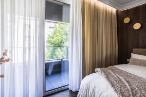 sypialnia z łóżkiem i dużym oknem w obiekcie Luksusowy Apartament Przy Filharmonii w mieście Katowice