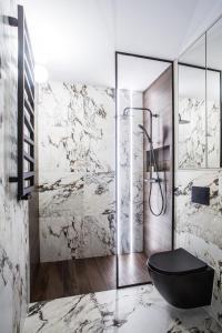 a bathroom with a black toilet and a shower at Luksusowy Apartament Przy Filharmonii in Katowice