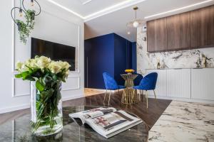 a living room with a vase of flowers on a table at Luksusowy Apartament Przy Filharmonii in Katowice