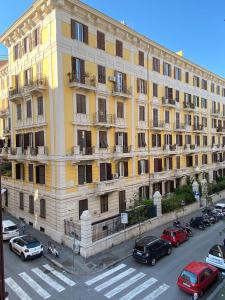 ein großes gelbes Gebäude mit Autos auf einem Parkplatz in der Unterkunft Apartment Centro Parioli in Rom