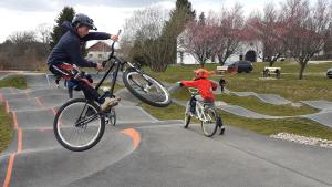 2 personnes en vélo faisant des tours dans un skatepark dans l'établissement Les Woodies, à Xertigny