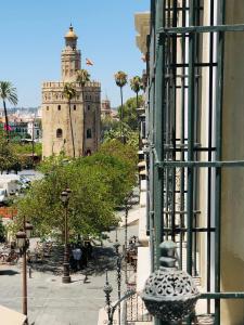 een gebouw met een klokkentoren op de achtergrond bij Hotel Tayko Sevilla in Sevilla