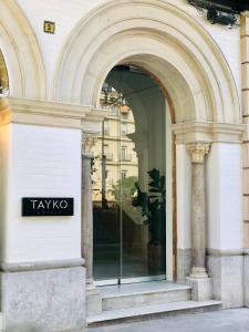 Hotel Tayko Sevilla في إشبيلية: نافذة مبنى عليها لافتة