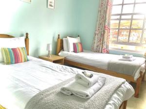 a bedroom with two beds with towels on them at The Pier Inn in Whitby