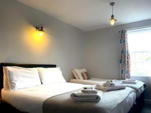a bedroom with two beds with towels on the bed at The Pier Inn in Whitby