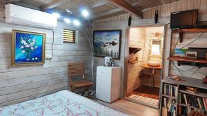 Habitación pequeña con nevera y silla en Grand Kaz'Amour - 3 étoiles, en Bouillante