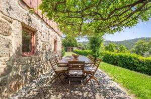 una mesa y sillas sentadas fuera de un edificio de piedra en Casa Castel'Rei, en Guimarães