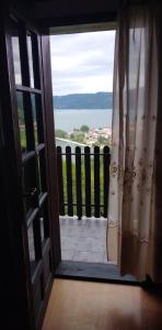 an open door to a balcony with a view of the water at B&B Jonovic in Donji Milanovac