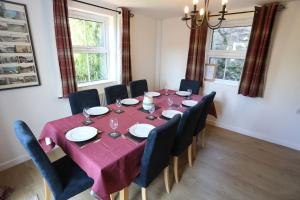 a dining room table with chairs and a red table cloth at Ashdale Cottage cosy 4 bedroom holiday home near Amroth in Pembrokeshire