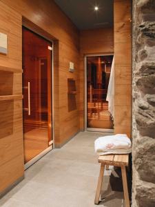 Cette chambre est dotée de murs en bois et d'une porte avec un banc. dans l'établissement BEAUSiTE Zermatt, à Zermatt