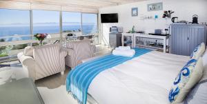 サイモンズタウンにあるPenguins View Guesthouseの海の景色を望むベッドルーム1室(大型ベッド1台付)