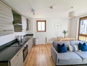 a living room with a couch and a kitchen at Brooklands Central Apartment in Newcastle