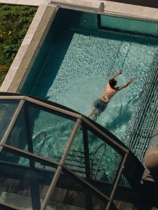 a man is swimming in a swimming pool at BEAUSiTE Zermatt in Zermatt