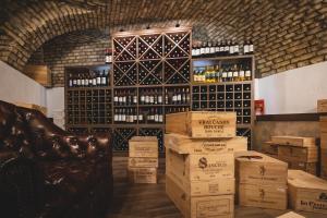 a room with boxes of wine and a shelf of wine bottles at Artist hotel in Subotica