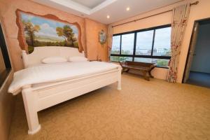 ein Schlafzimmer mit einem großen weißen Bett und einem Fenster in der Unterkunft Thongtara House Boutique Srinakarin in Bangkok