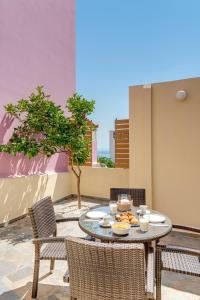 een tafel en stoelen met eten op een patio bij Cova Philoxenia House in Ermoupoli