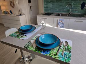 una mesa con platos y utensilios azules en la cocina en Mansarda al mare, en Rapallo