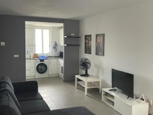 uma sala de estar com um sofá e uma televisão de ecrã plano em Sunny apartment Benidorm em Cala de Finestrat
