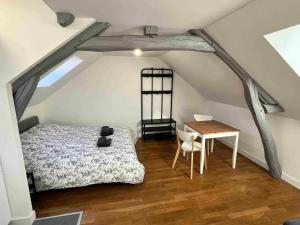 1 dormitorio con cama y mesa en el ático en Hyper centre ville STUDIO, en Angers