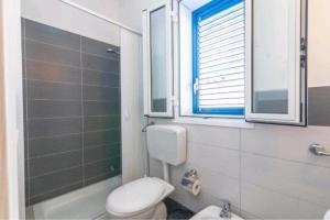 bagno con servizi igienici, lavandino e finestra di Casa vacanza Marietta a Noto Marina