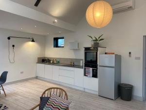 a kitchen with white cabinets and a refrigerator at May Road, stylish townhouse in Twickenham