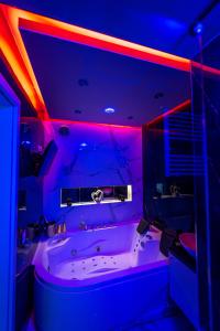 ビャウィストクにあるArt Stylのバスルーム(紫と青の照明付きのバスタブ付)
