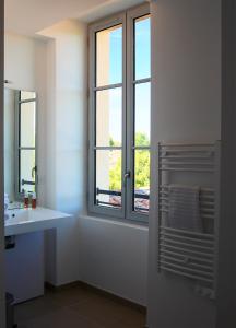 łazienka z umywalką i oknem w obiekcie Première Pierre w mieście Verdelais
