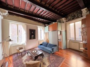 een woonkamer met een blauwe bank en een tafel bij Guest House Bandini: eleganza nel cuore di Siena in Siena
