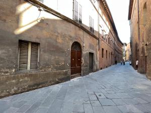 een lege straat in een steeg tussen twee gebouwen bij Guest House Bandini: eleganza nel cuore di Siena in Siena