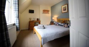 a bedroom with a bed with two teddy bears on it at Grenitote B&B in Portree