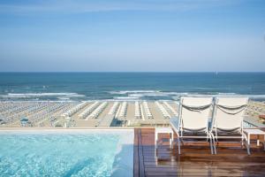 two chairs sitting on the deck of a resort with the beach at Grand Hotel Principe Di Piemonte in Viareggio