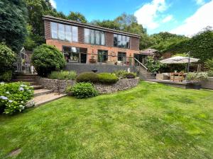 a house with a lawn in front of it at Stunning Surrey Hills Country House set in half an acre in Hindhead