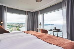 ein Schlafzimmer mit einem Bett und einem Schreibtisch mit einem großen Fenster in der Unterkunft Quality Hotel Match in Jönköping