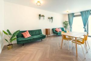 uma sala de estar com um sofá verde e uma mesa em City Centre Loft Residence em Antuérpia