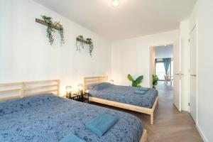 um quarto com 2 camas e lençóis azuis em City Centre Loft Residence em Antuérpia