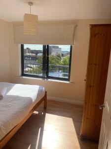 a bedroom with a bed and a large window at City Centre Penthouse in Southampton