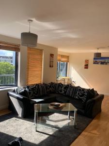 a living room with a black couch and a table at City Centre Penthouse in Southampton