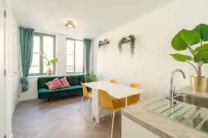 uma sala de estar com um sofá verde e uma mesa em City Centre Loft Residence em Antuérpia