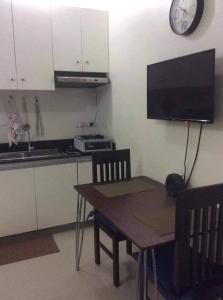 eine Küche mit einem Tisch und einer Uhr an der Wand in der Unterkunft Kassel residences condo in Manila