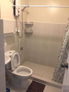 a small bathroom with a toilet and a shower at Kassel residences condo in Manila