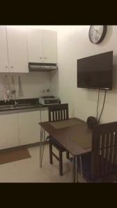 eine Küche mit einem Holztisch sowie einem Tisch und Stühlen in der Unterkunft Kassel residences condo in Manila