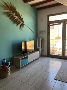 a living room with a flat screen tv on a entertainment center at Casa Gino in Cotillo