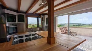 a living room with a table and some windows at Le panorama des Hautes-Côtes in Fussey