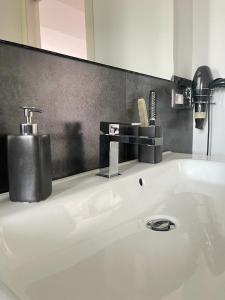 bagno con lavandino bianco e specchio di Timpa House Alle Pendici Dell'Etna a Paterno