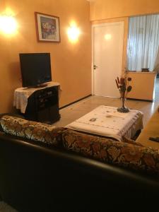 a living room with a table with a tv on it at Room in Guest room - Property located in a quiet area close to the train station and town in Casablanca