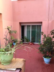 a patio with potted plants in front of a pink building at Room in Guest room - Property located in a quiet area close to the train station and town in Casablanca