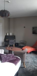 uma sala de estar com um sofá e uma mesa em Logis Hôtel Le Grand Cerf em Ernée
